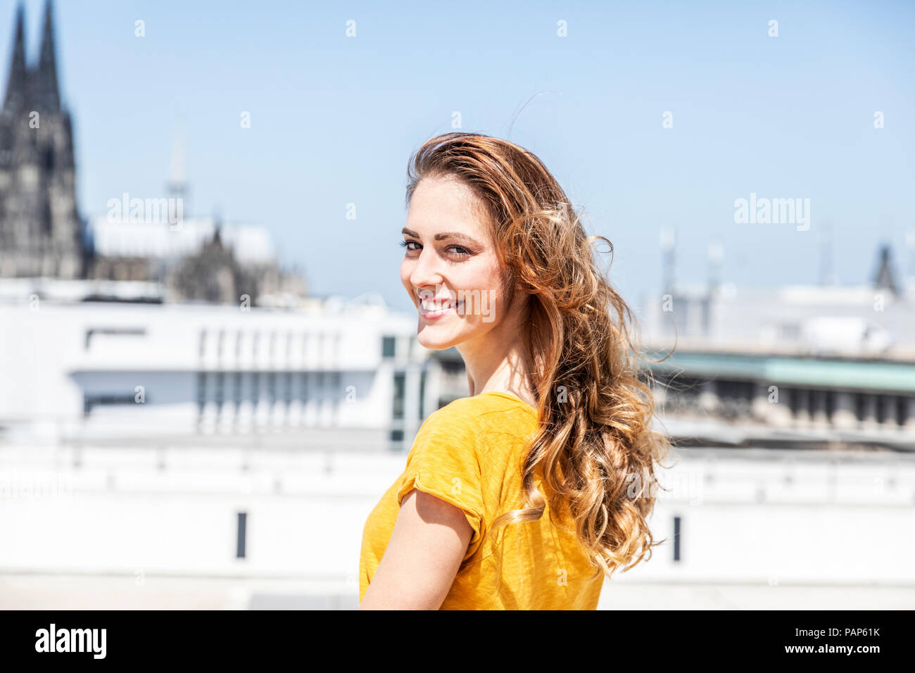 Allemagne, Cologne, portrait of smiling woman sur la terrasse du toit Banque D'Images