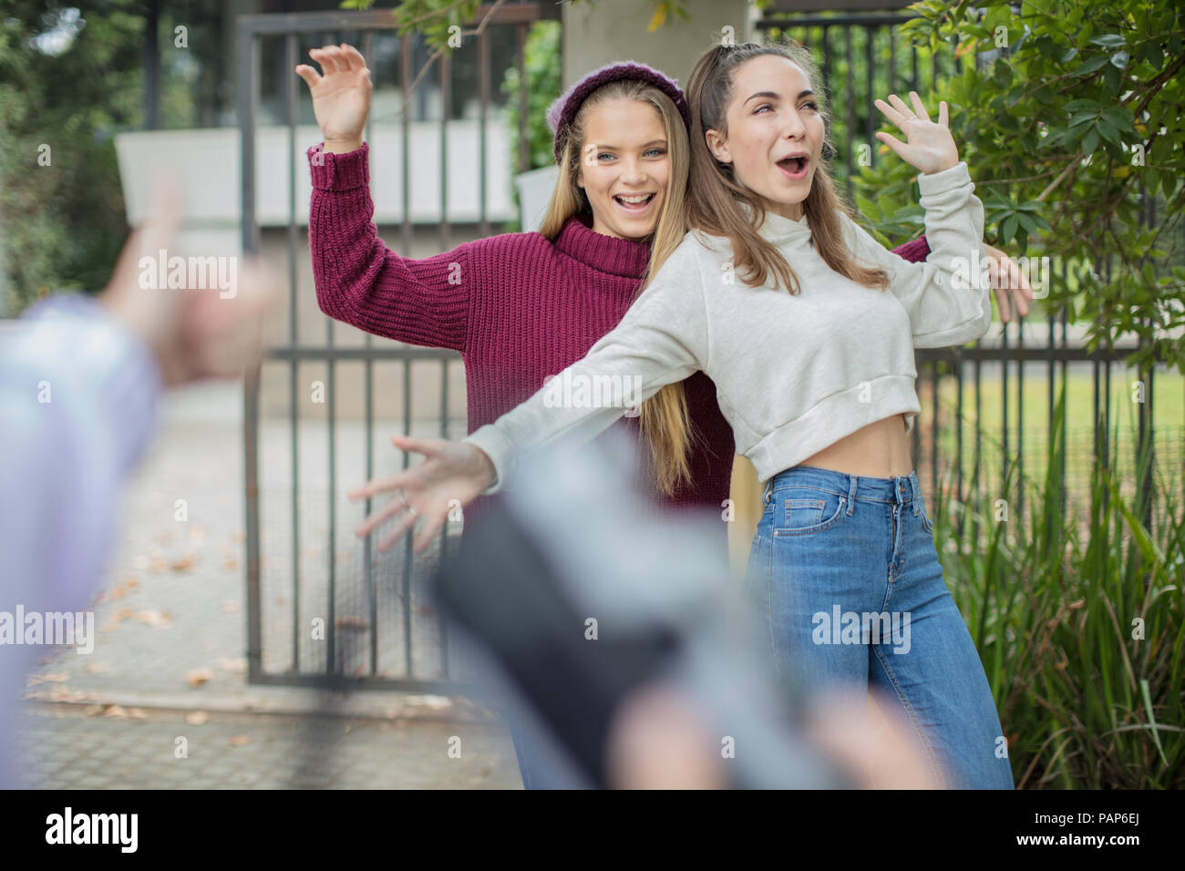 Adolescente de prendre une photo de son happy friends outdoors Banque D'Images