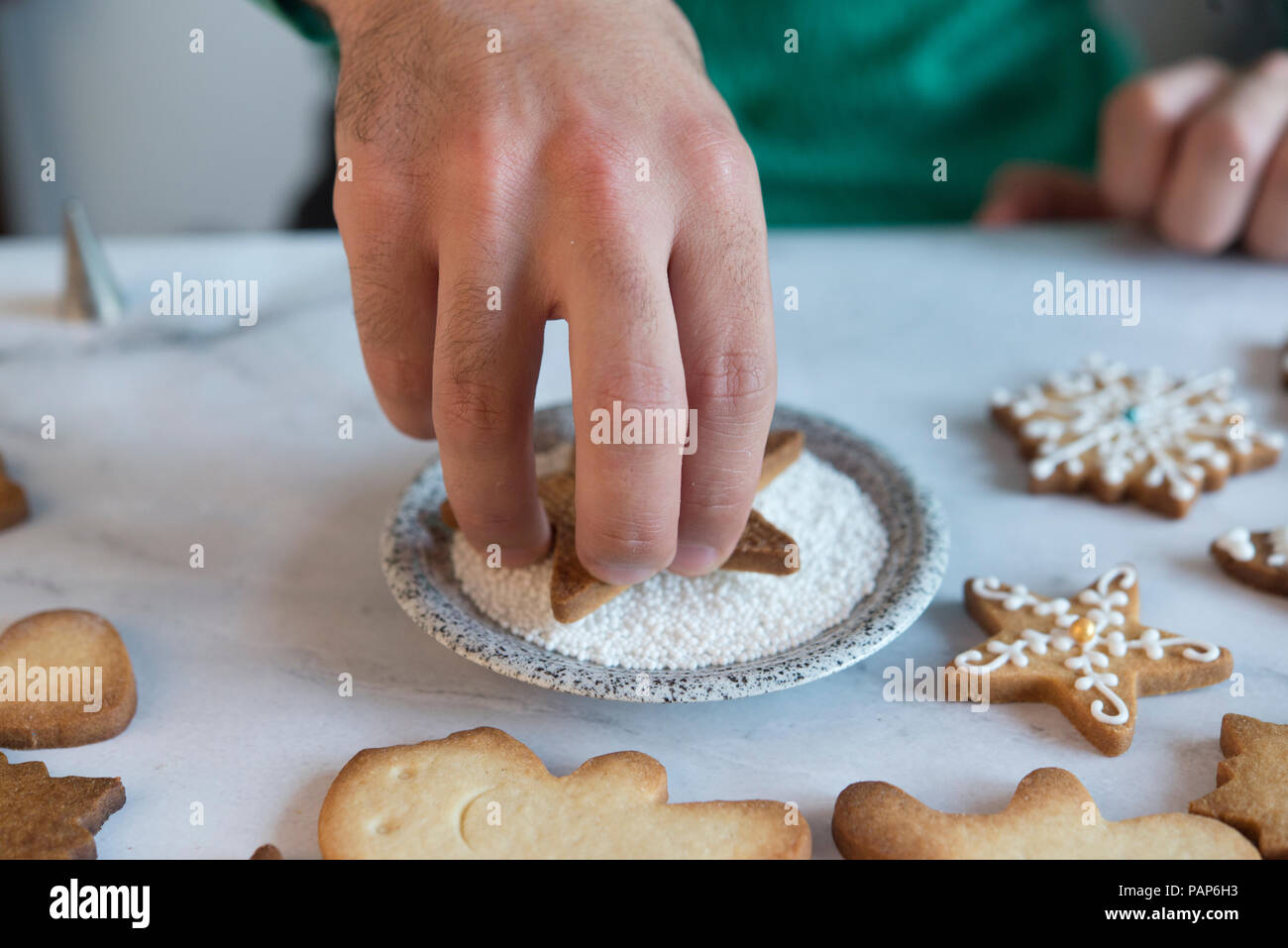 Man's hand decorating Christmas Cookies, close-up Banque D'Images