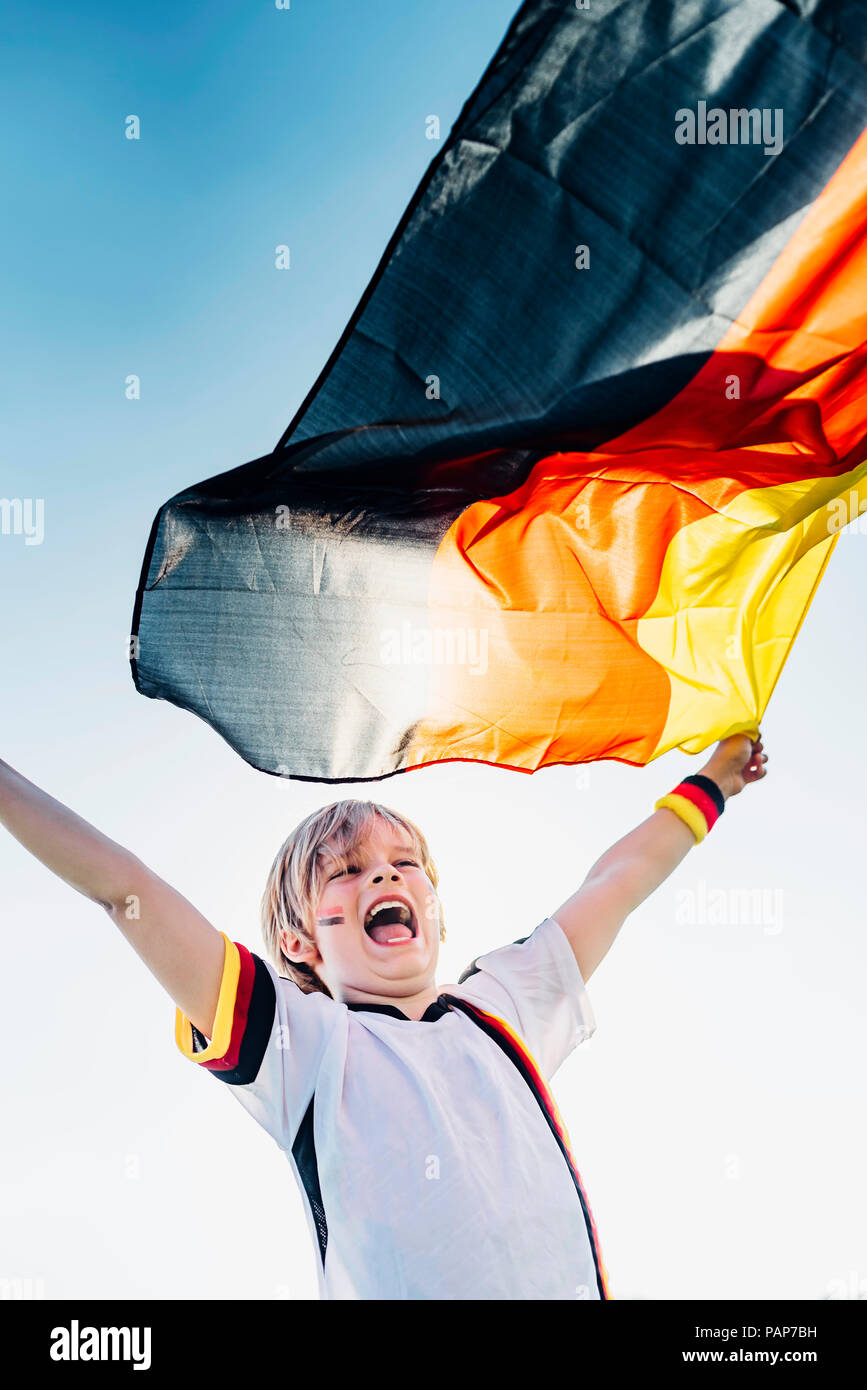 Garçon, enthousiaste pour le championnat du monde de soccer, en agitant le drapeau allemand Banque D'Images