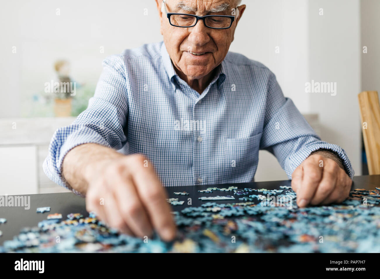 Faire un puzzle denteux Senior man Banque D'Images