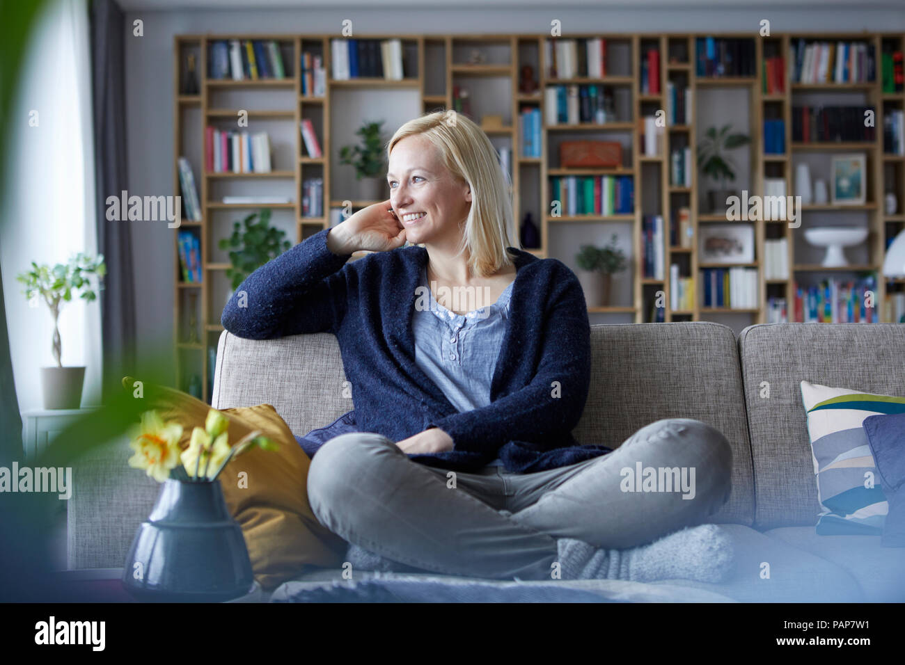 Woman relaxing at home, sitting on couch Banque D'Images