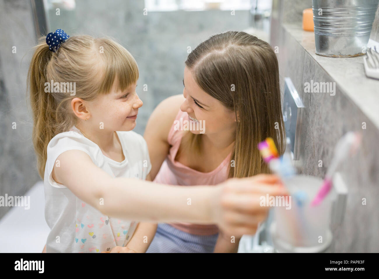 Mère et fille se brosser les dents dans la salle de bains Banque D'Images