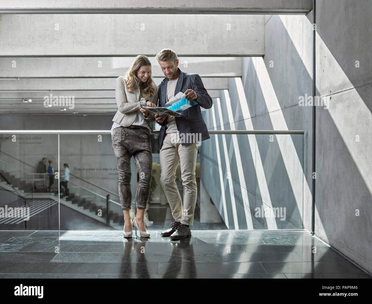 L'homme et de la femme partager livret sur plancher de bureau Banque D'Images