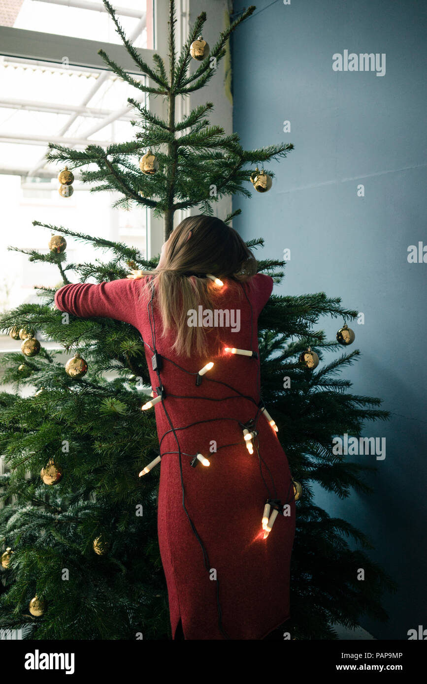 Vue arrière de l'arbre de Noël woman hugging Banque D'Images