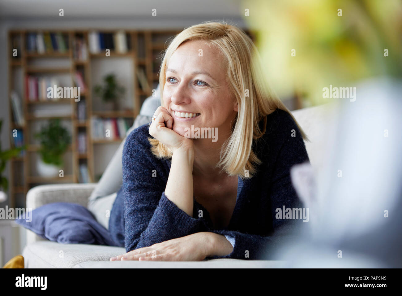 Woman relaxing at home, sitting on couch Banque D'Images