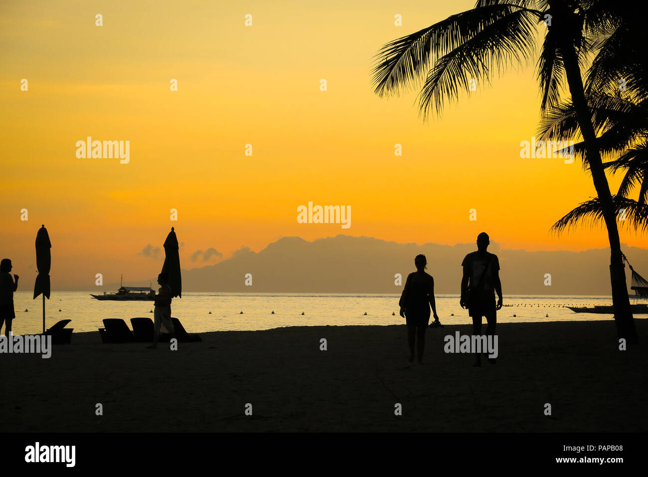 Deux silhouettes touristiques à un Fiery orange island sunset - Panglao, Philippines Banque D'Images