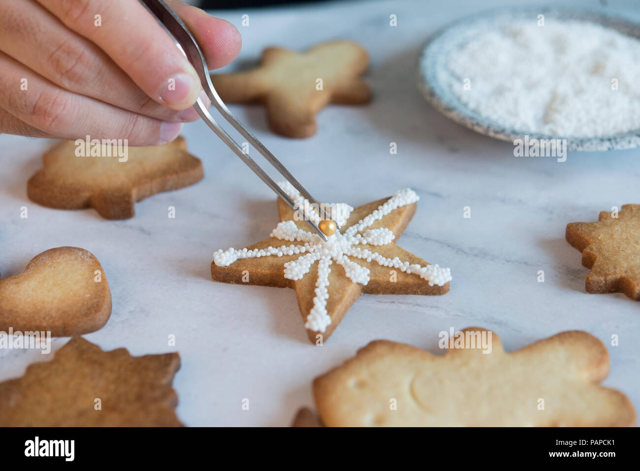 Man's hand decorating Christmas Cookies, close-up Banque D'Images