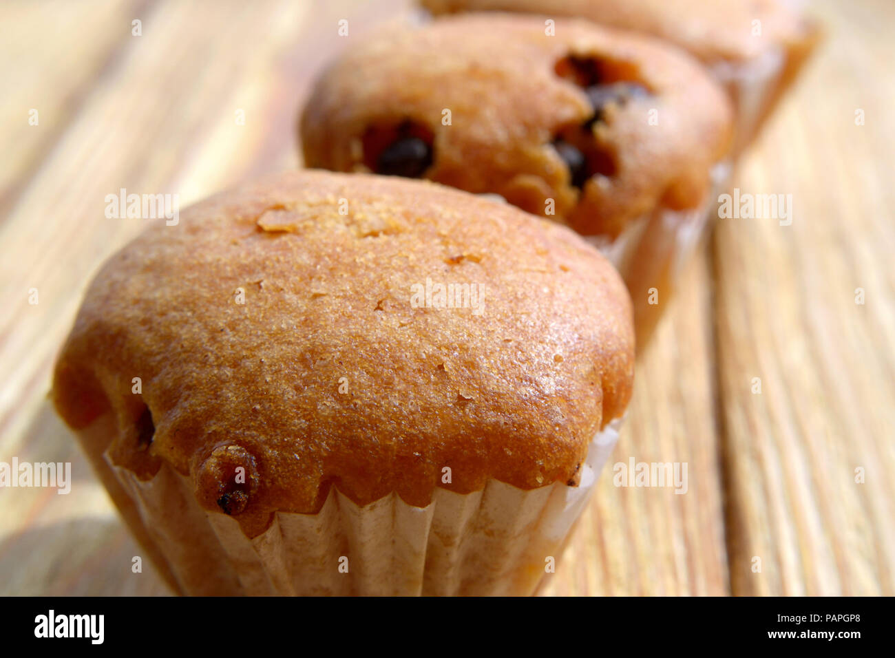 Muffins dans une rangée sur un fond de bois Banque D'Images