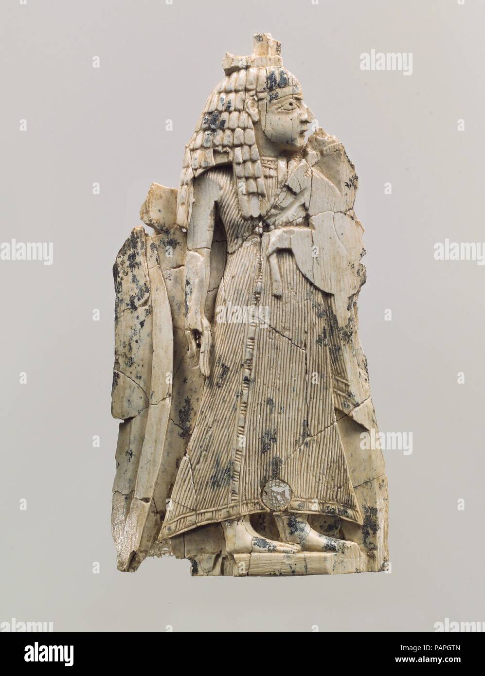 Plaque de meubles sculptés en relief avec une figure féminine. Culture : l'assyrien. Dimensions : 4.33 x 2.2 x 0.31 in. (11 x 5,59 x 0,79 cm). Date : ca. 9ème-8ème siècle avant J.-C.. Cette pièce a été trouvée dans un cellier à Fort Shalmaneser, un bâtiment royal à Nimrud c'était probablement utilisé pour stocker et rendre hommage booty recueillies par les Assyriens en campagne militaire. Le caractère fragmentaire, plaque rectangulaire représente une figure féminine avec sa tête le profil tourné vers la droite. Elle est vêtu d'un short, cheville-longueur vêtement qui est bordée sur les bords. Bien que son bras gauche est abrasée, une tige florale peut encore être vu Banque D'Images