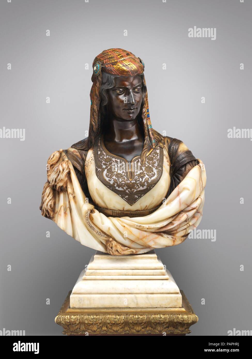 La femme juive d'Alger. Artiste : Charles-Henri-Joseph Cordier (Français, 1827-1905). Culture : français, Paris. Dimensions : Hors Tout sur socle (confirmé) : H. 35 1/2 x 1/4 x 25 W. D. 13 3/4 in., 265lb. (90,2 x 64,1 x 34,9 cm, kg 120.2032) [Poids : 37 lb, tête buste en marbre 228 lbs ; socle en marbre 100,7 lbs] ; socle (confirmé) : H. 41 x 3/8 x 1/4 18 W. D. 18 1/4 x 11 3/4 in., 551.2lb. (105,1 x 46,4 x 46,4 x 29,8 cm, 250kg). Bouilloire : piédestal attribuée aux dessins et modèles industriels par Charles-François Rossigneux (Français, 1818-1909 afer). Date : 1862. Dans ses mémoires inédits Charles Cordier cite la Loi de Banque D'Images