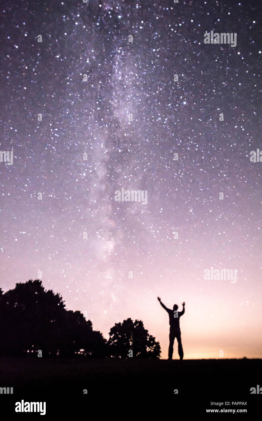 Homme qui prie, louant Dieu, en regardant la Voie Lactée vu de Sussex, UK, Juillet Banque D'Images