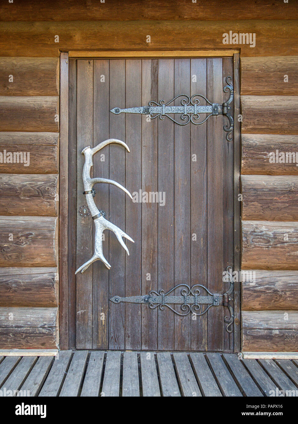 L'ancienne porte en bois, avec le bois de la poignée dans un log mur Banque D'Images