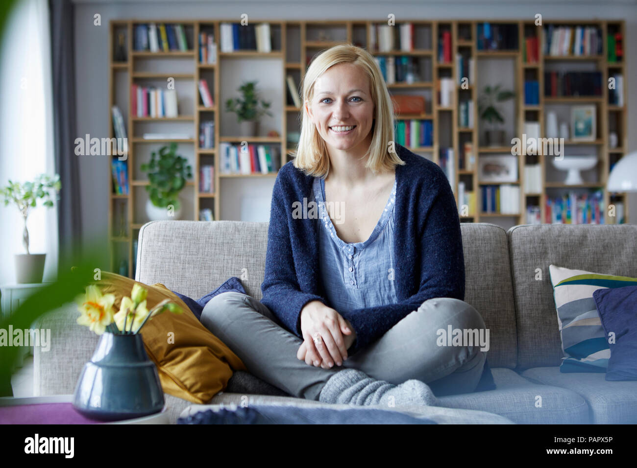 Woman relaxing at home, sitting on couch Banque D'Images