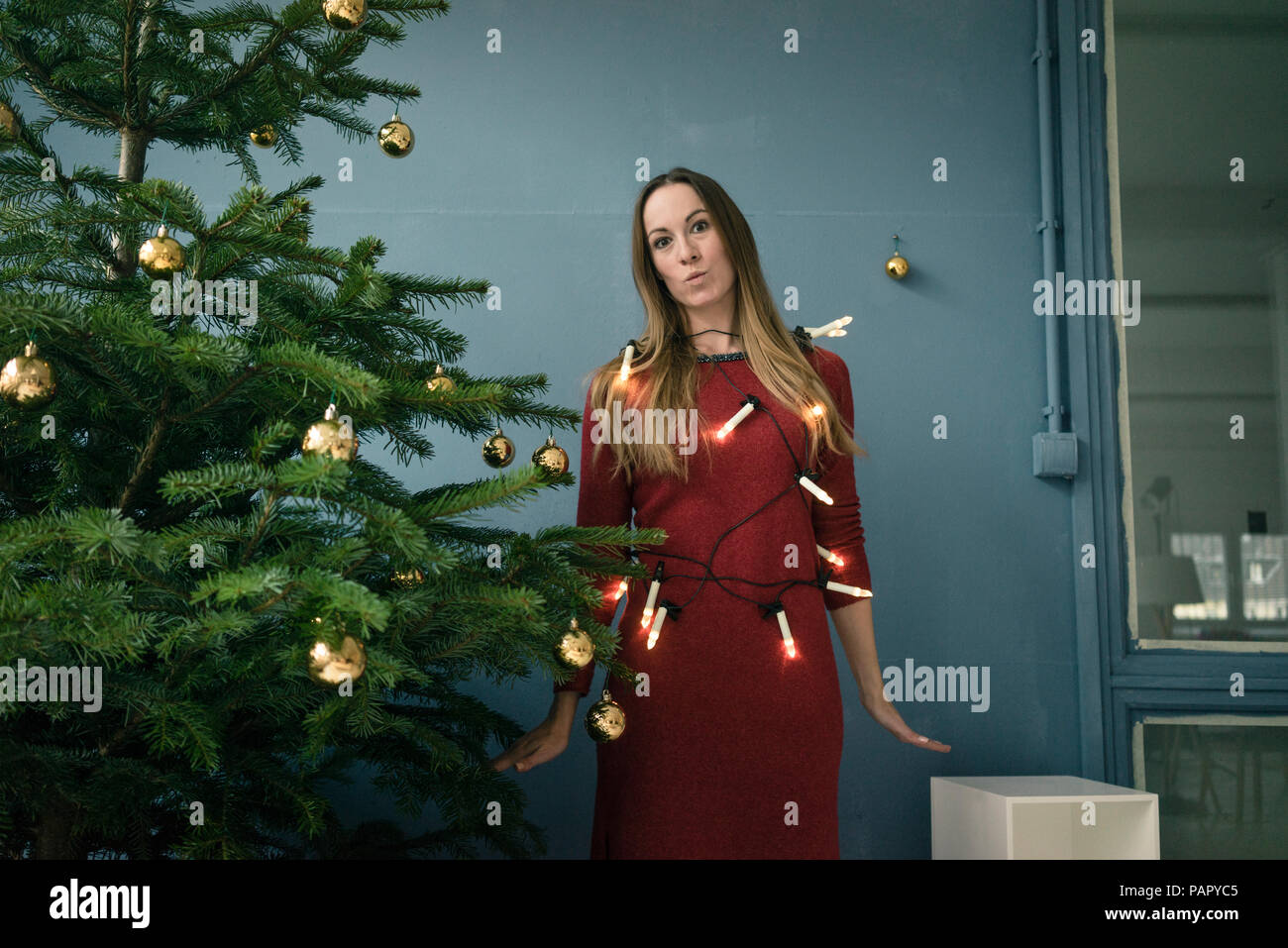Portrait de femme avec des lumières d'arbre de Noël d'ailleurs permanent Banque D'Images Portrait de femme avec des lumières d'arbre de Noël d'ailleurs permanent Banque D'Images