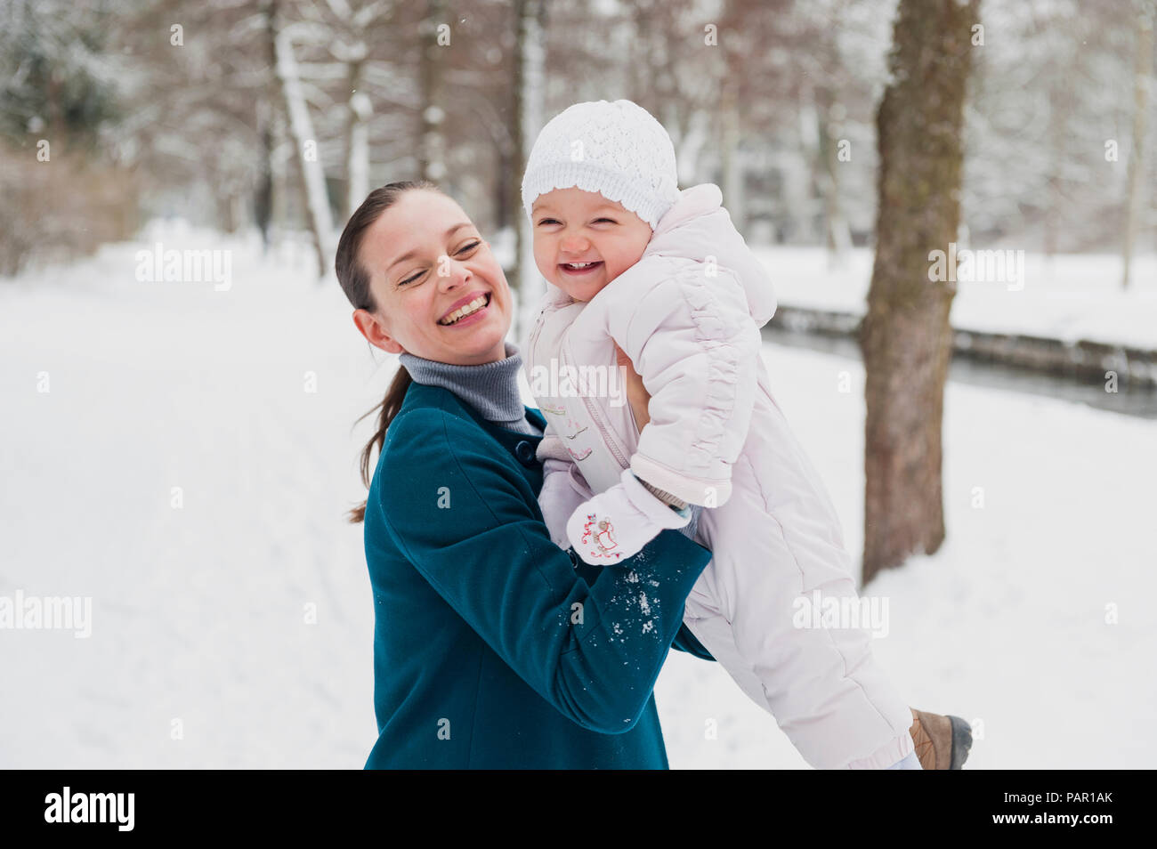 Portrait of happy baby girl s'amusant avec sa mère dans un paysage couvert de neige Banque D'Images