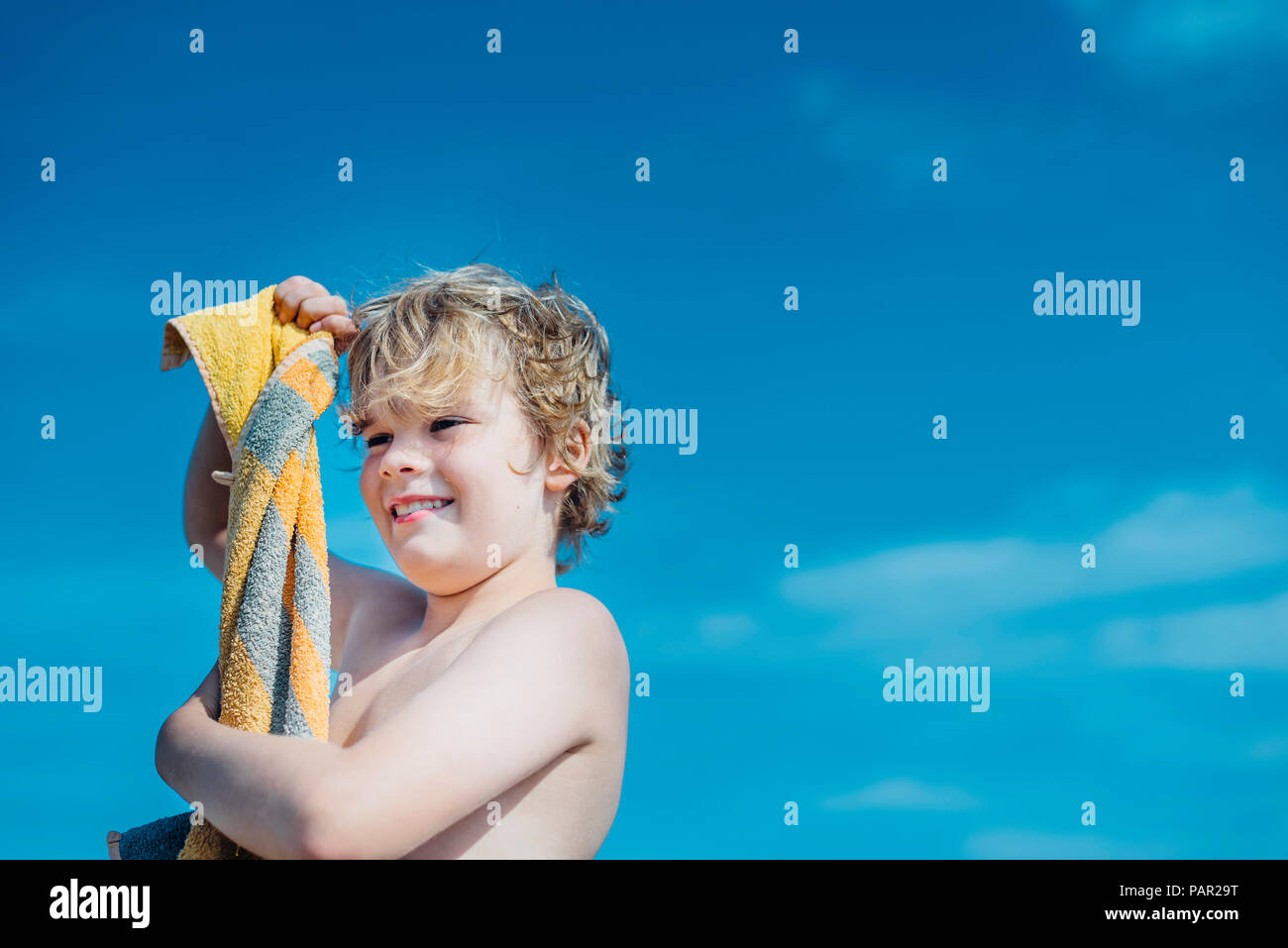 Portrait of happy boy avec serviette de plage en plein air Banque D'Images