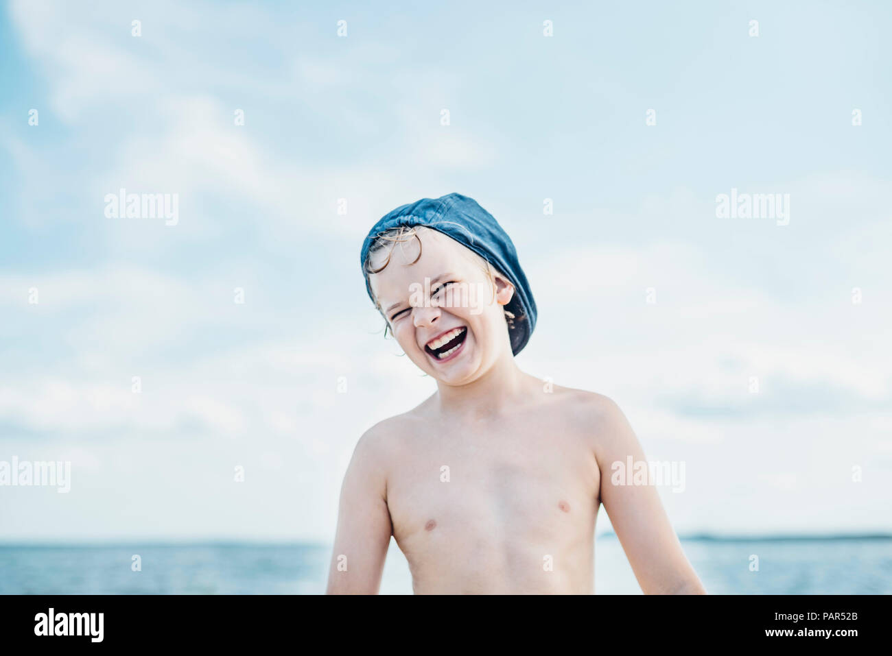 Portrait of happy boy portant une casquette à la mer Banque D'Images