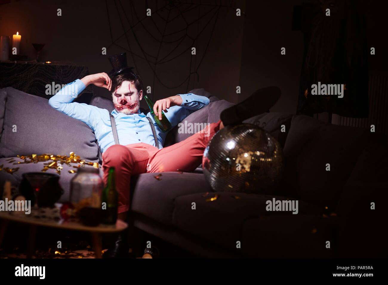 L'homme en costume Halloween dormir sur table après partie Banque D'Images