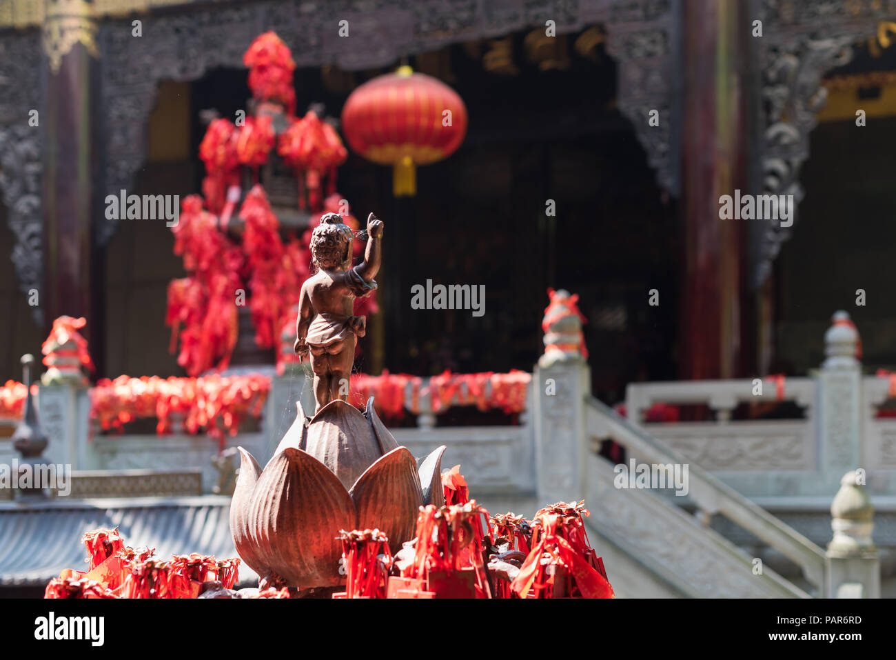 Statue de Bouddha debout sur une fleur de lotus avec bandes rouges dans LuoHanCi temple Chongqing, Chine Banque D'Images