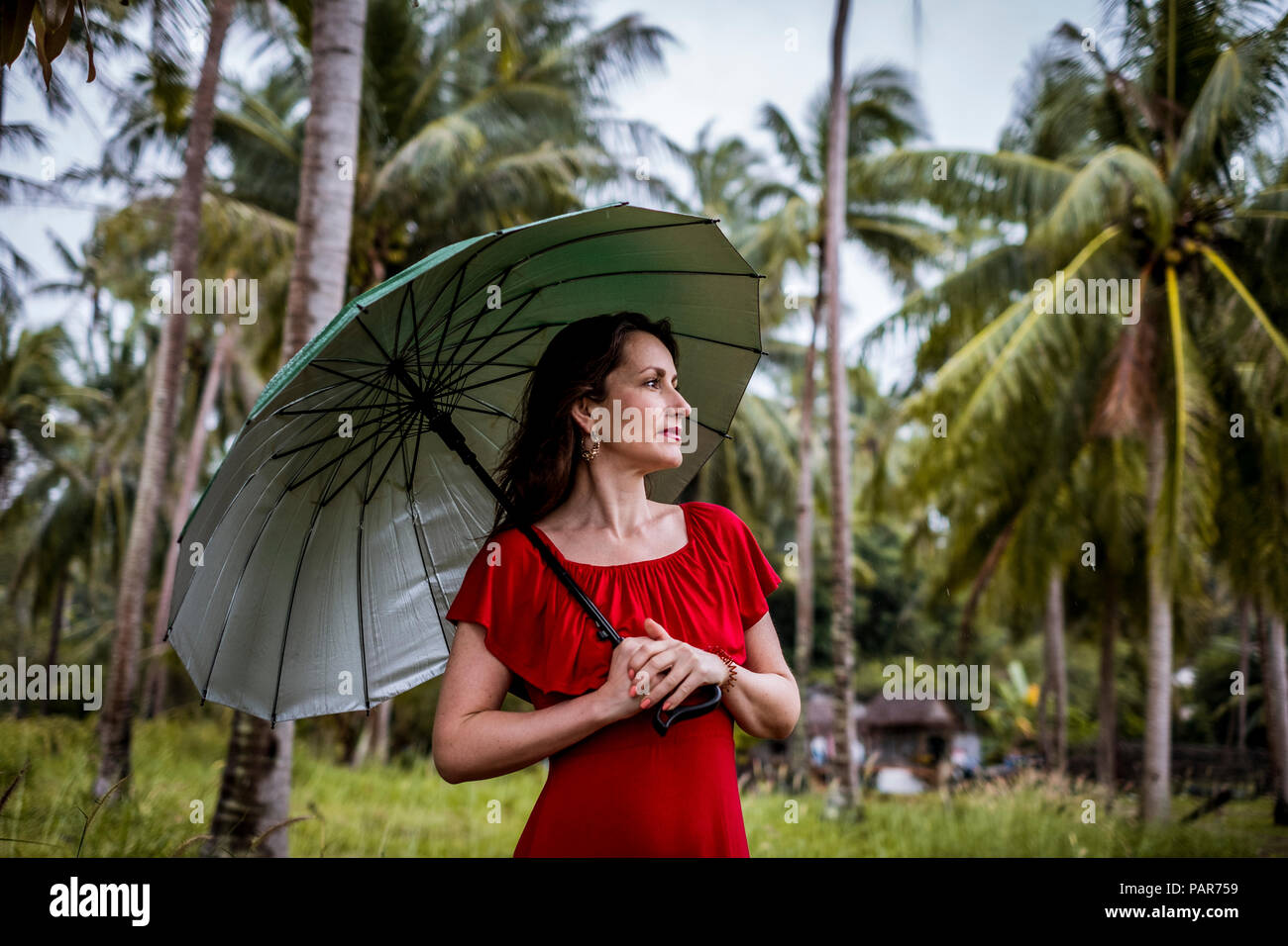 La Thaïlande, Koh Phangan, portrait de femme se promenant avec parapluie Banque D'Images