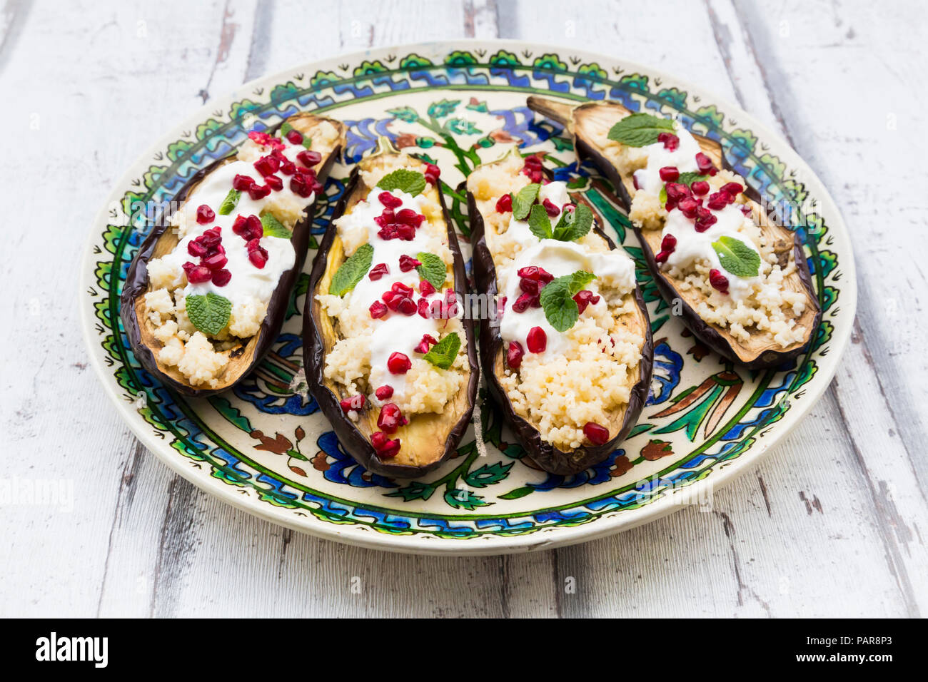 Rempli avec du couscous aubergines, sauce yogourt, menthe et graines de grenade Banque D'Images