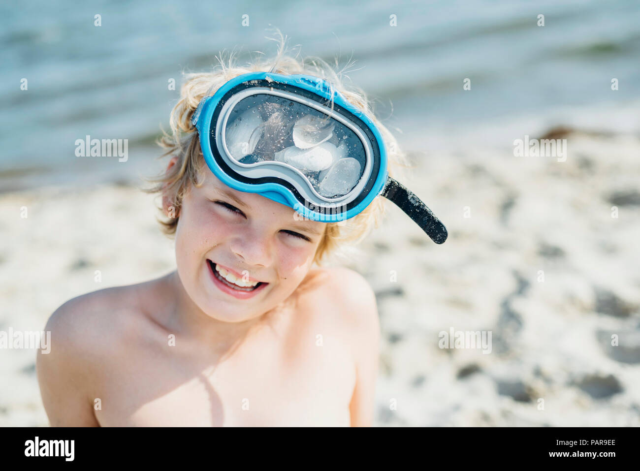 Portrait of happy boy portant un masque de plongée sur la plage Banque D'Images