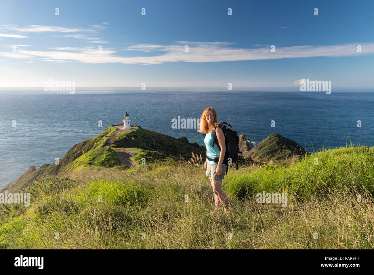 Femme se tient en face de phare à Cape Reinga, Northland, North Island, New Zealand Banque D'Images
