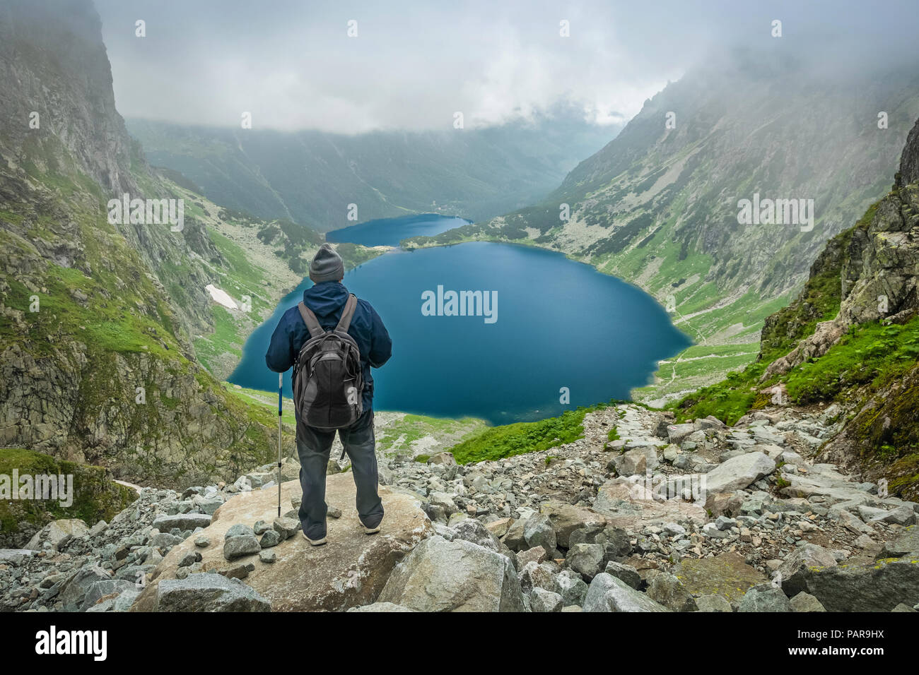Un homme avec des bâtons de marche et sac à dos d'un séjour et vous recherchez à Czarny Staw pod Rysami Morskie Oko et lacs de montagnes Tatra Banque D'Images