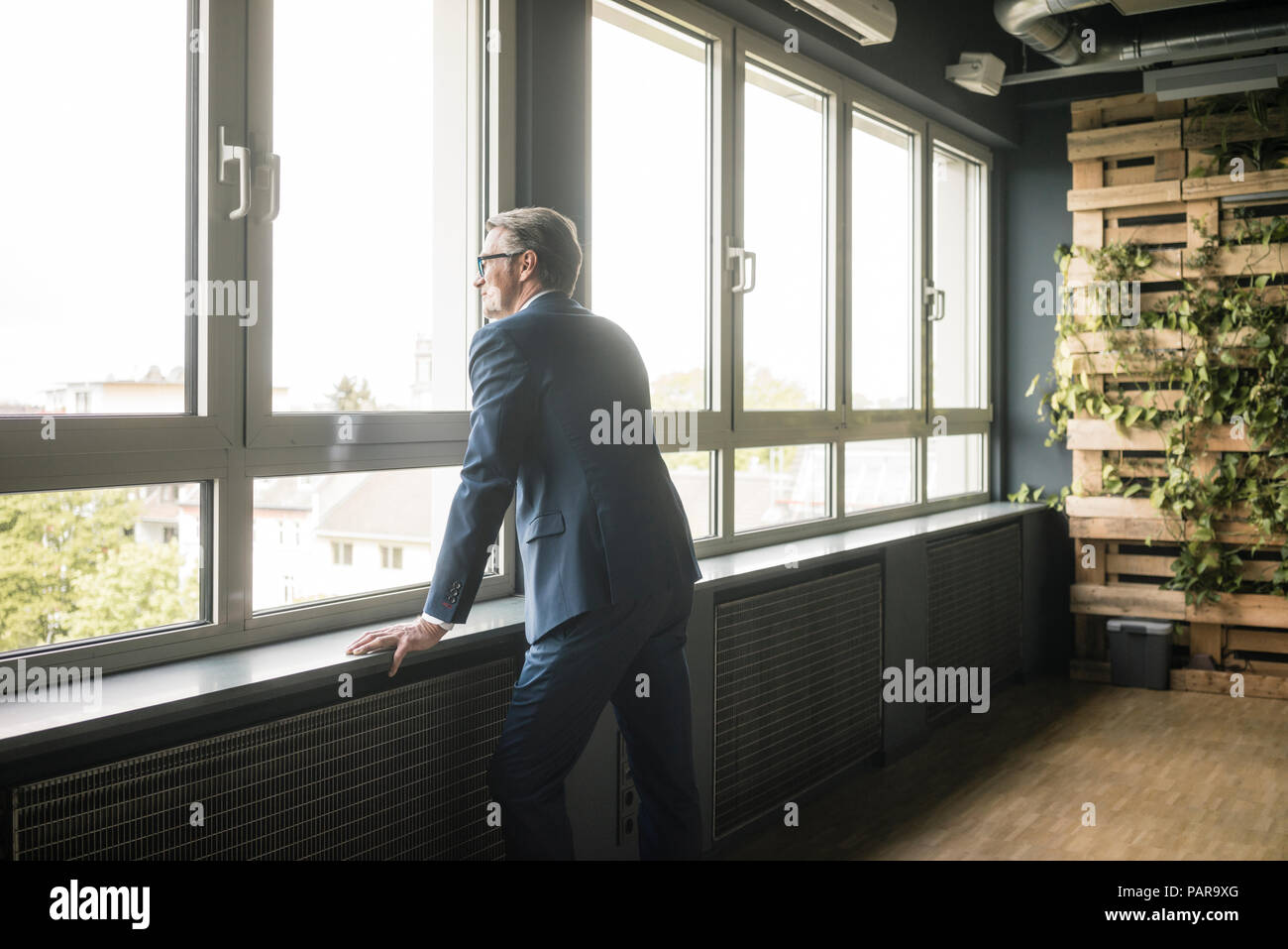 Businessman standing in office à la fenêtre Banque D'Images