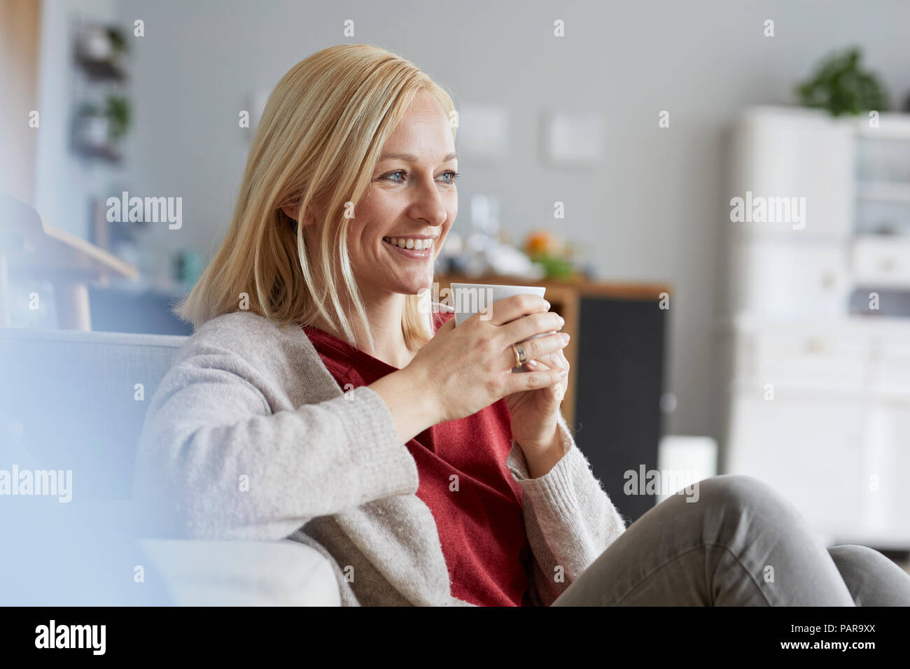 Happy woman relaxing at home, boire du café Banque D'Images