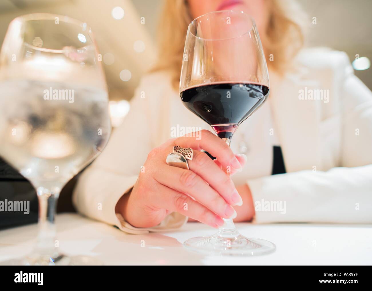 Femme avec un verre de vin dans l'élégant restaurant. Photo gros plan. Banque D'Images