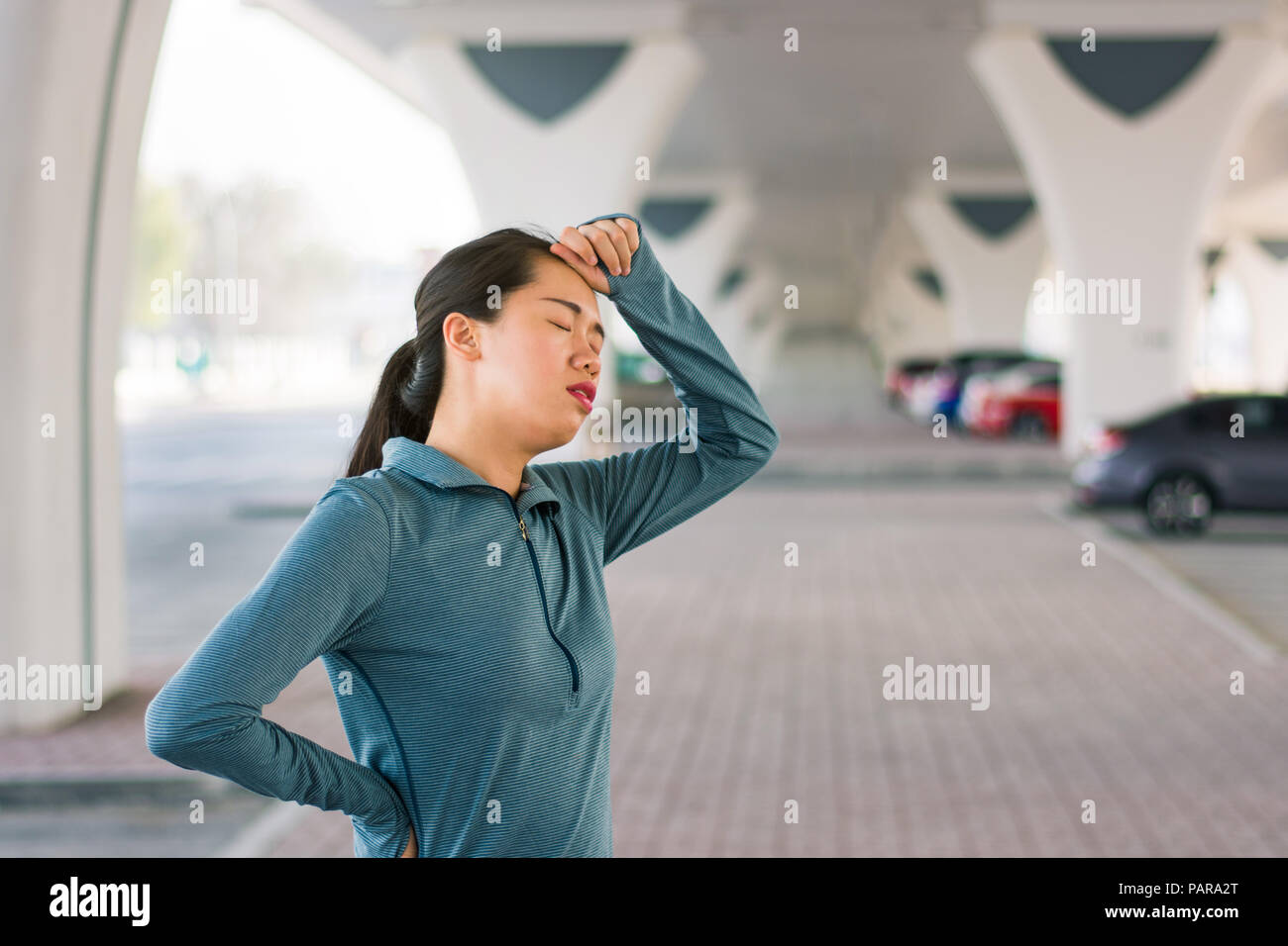 Girl étirements avant d'entraînement sur le terrain de stationnement en plein air Banque D'Images