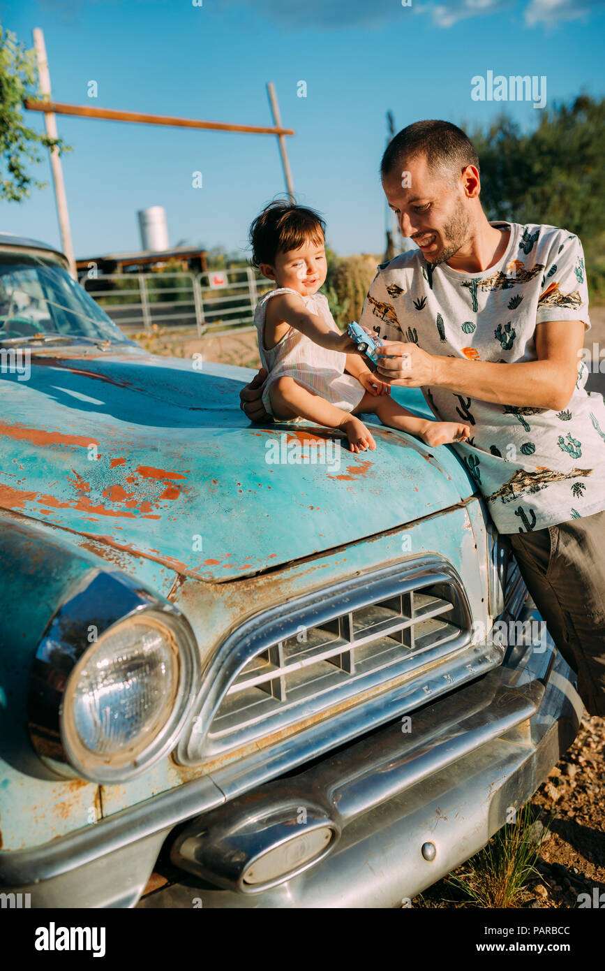 USA, Arizona, le Père et l'enfant jouant avec une reproduction d'une vieille voiture d'époque, sur la Route 66 Banque D'Images