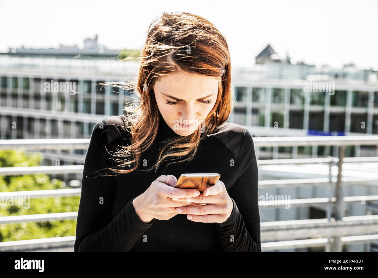 Woman text messaging on toit-terrasse Banque D'Images