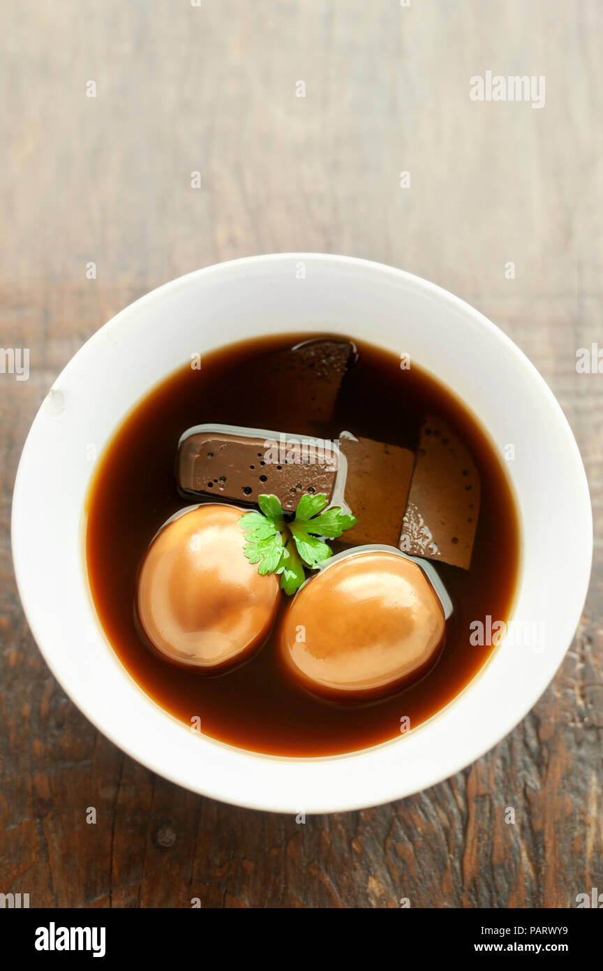 Les œufs et le porc cuit dans la sauce sucrée sur table en bois, de la nourriture thaïe. Banque D'Images