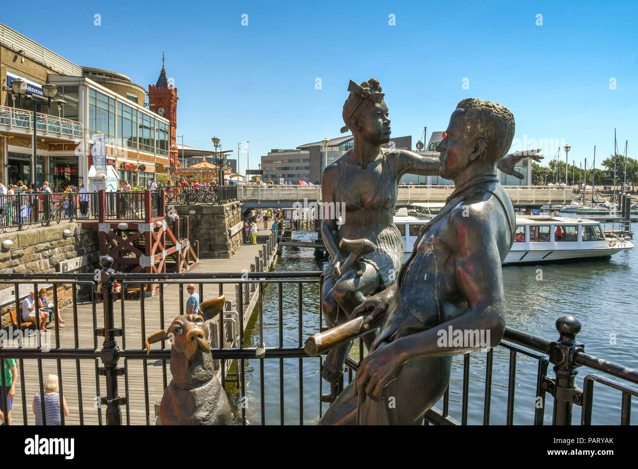 La sculpture en bronze "des gens comme nous" sur Mermaid Quay dans la baie de Cardiff. Un exemple d'art public, il est composé de deux jeunes gens et un chien. Banque D'Images