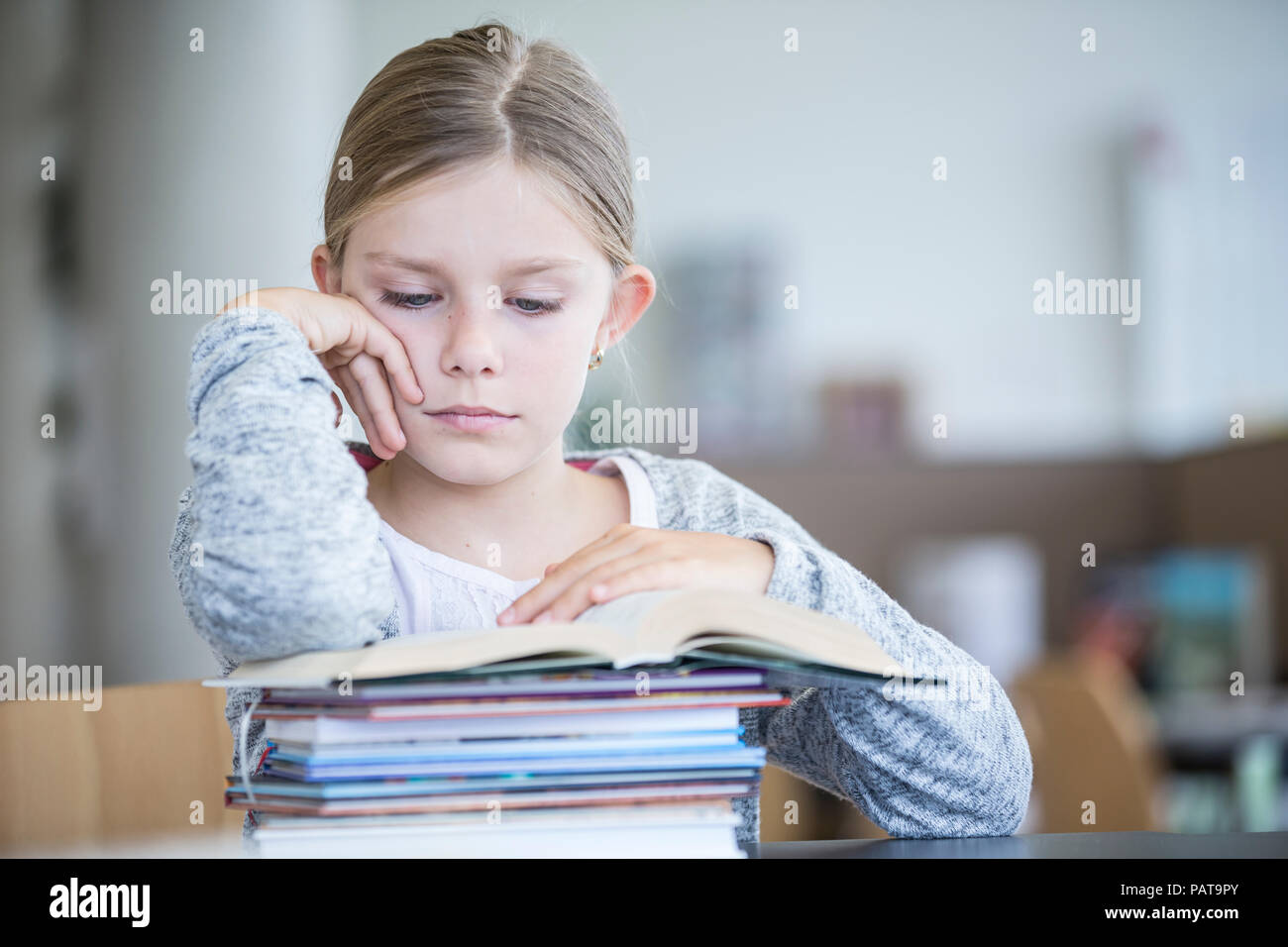 Lycéenne lecture livre sur le tableau à l'école Banque D'Images