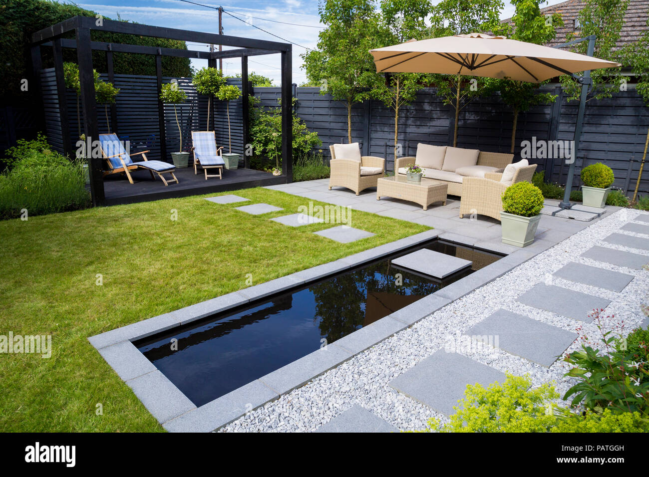 Sommaire des bordures de jardin avec un cube d'une pergola, d'un coin salon et d'une piscine Banque D'Images