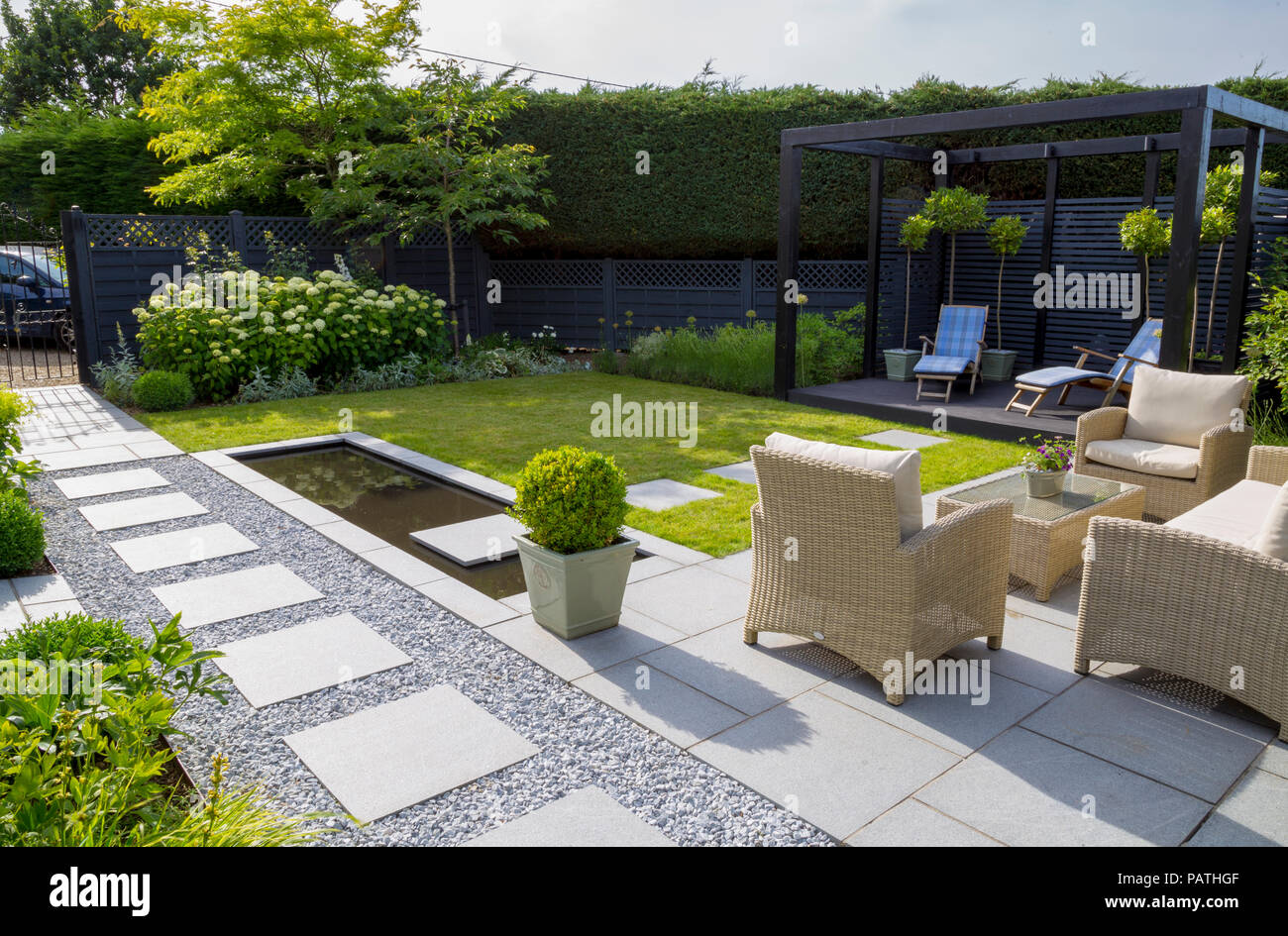 Sommaire des Frontières herbacées avec jardin, coin salon, piscine d''eau et un cube noir peint pergola Banque D'Images