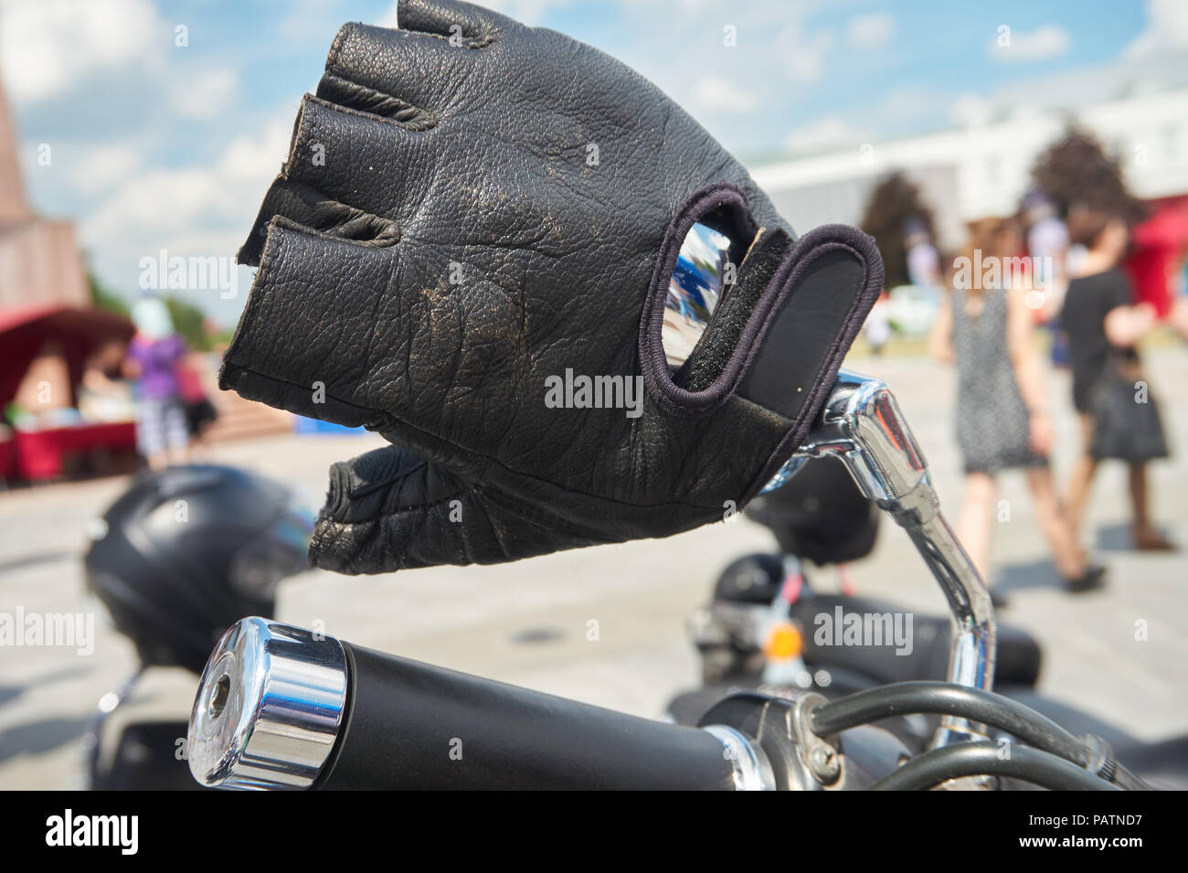 Gant mitaine en cuir noir ou sur le guidon d'une moto garée à l'extérieur  de la ville dans une vue en gros plan Photo Stock - Alamy