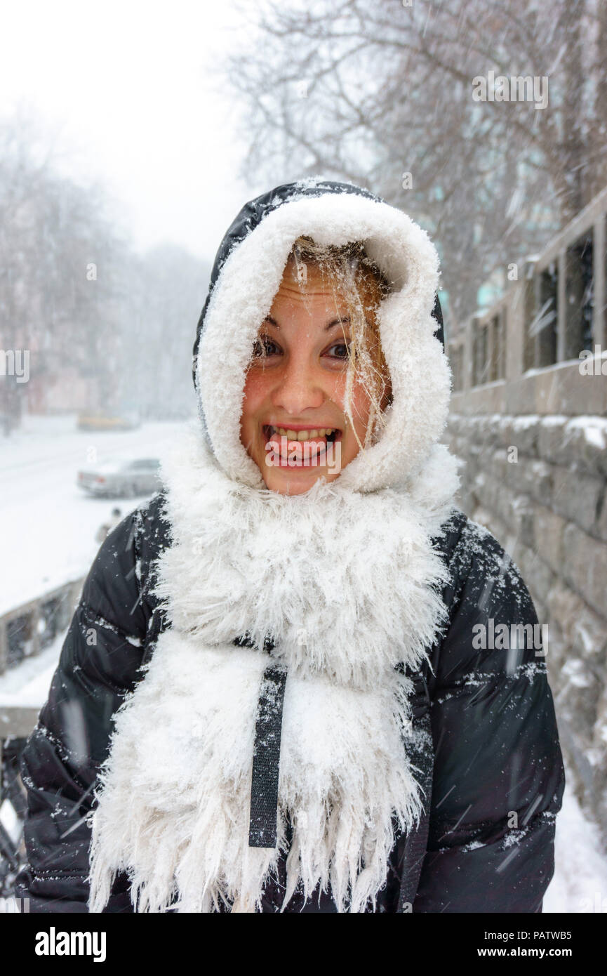 Funny Girl dans le capot et écharpe blanche montre sa langue dans la neige  hiver météo divertissement Photo Stock - Alamy