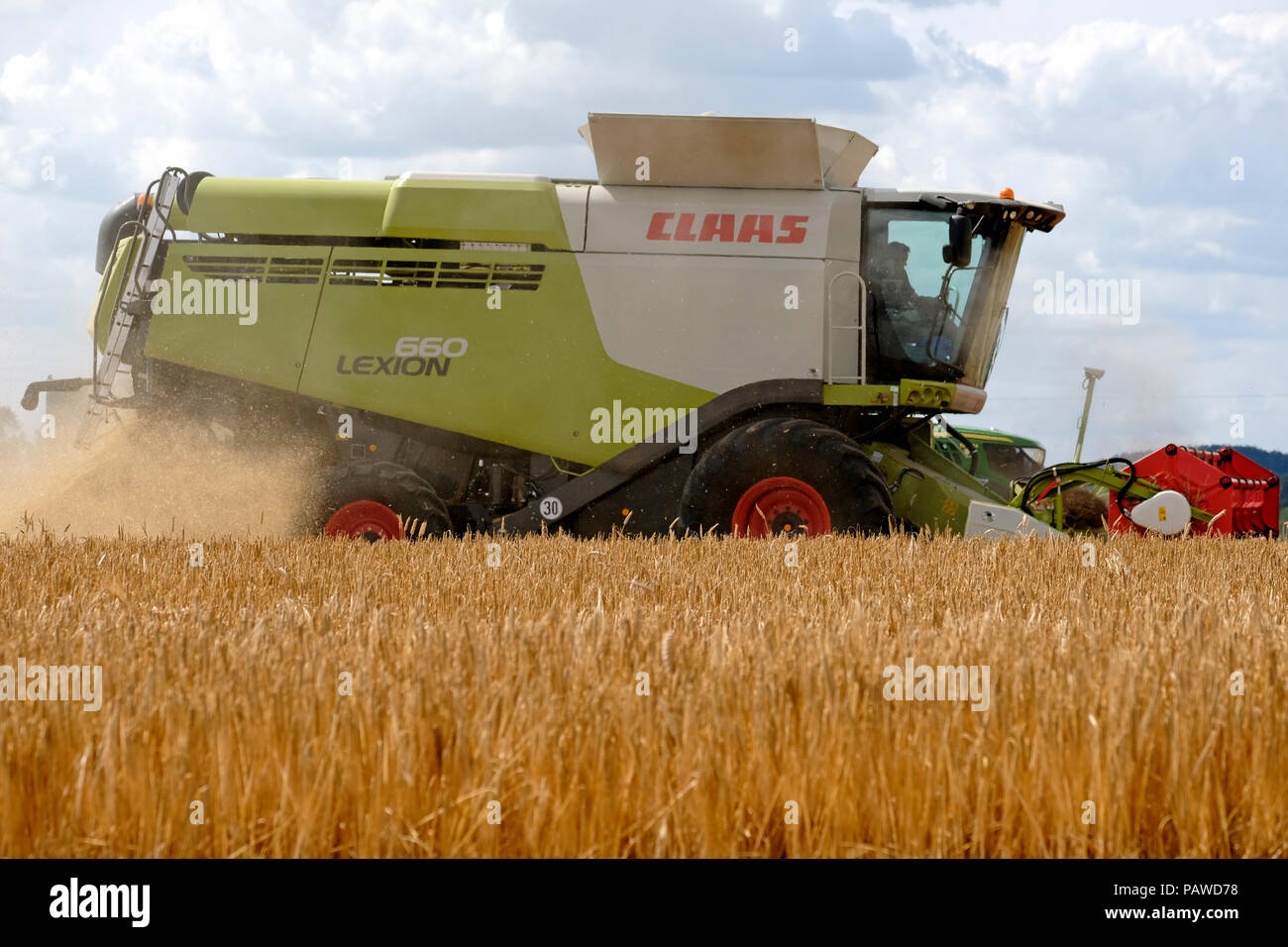 Kelso, Ecosse, 25 juillet 2018. Moissonneuse-batteuse dans Scottish Borders Tom Stewart de Sandyknowe Farm, près de Kelso dans les Scottish Borders, dans un rendmt Lexion Claas 660 Vario 770 avec barre de coupe à la moissonneuse-batteuse, qui travaillent dans les champs près de sa ferme, le mercredi 25 juillet 2018. Le transfert d'une culture à un tracteur d'attente pour passer à la ferme à quelques kilomètres de là. (Photo de Rob Gray / offres de crédit) : Rob Gray/Alamy Live News Banque D'Images
