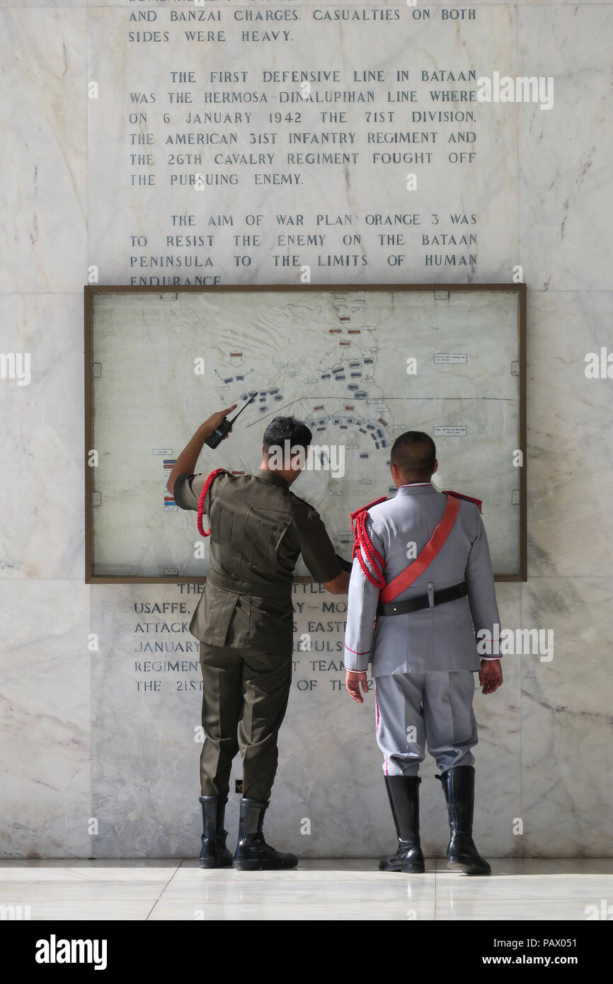 2 soldats militaires en civil l'examen de la bataille de Bataan site sur mur commémoratif au Mont Samat, Philippines Banque D'Images