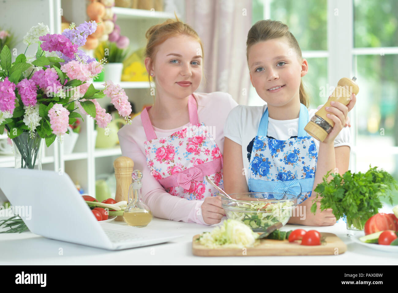 Deux funny girls préparer une salade fraîche Banque D'Images