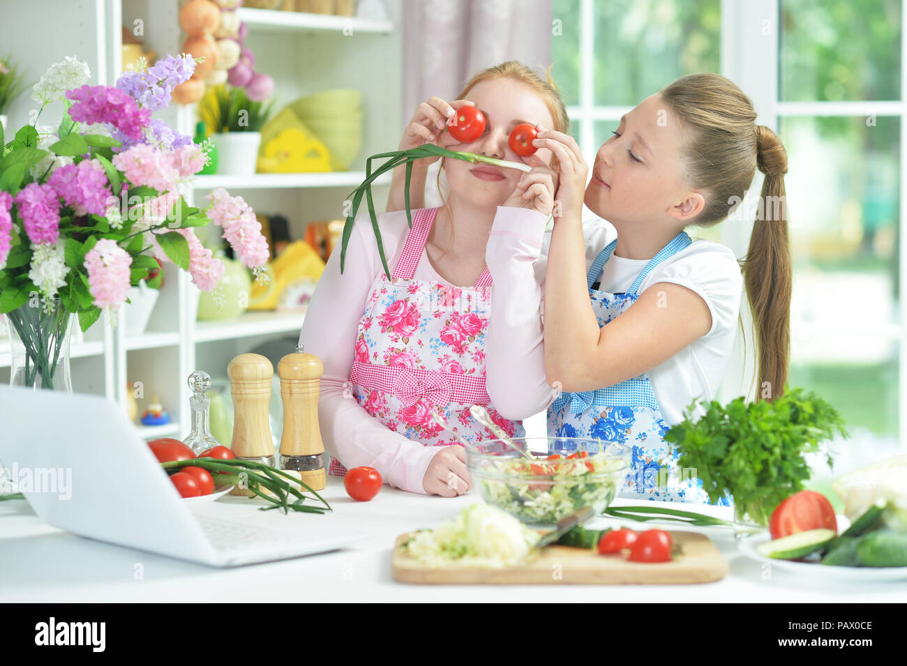 Deux funny girls préparer une salade fraîche Banque D'Images