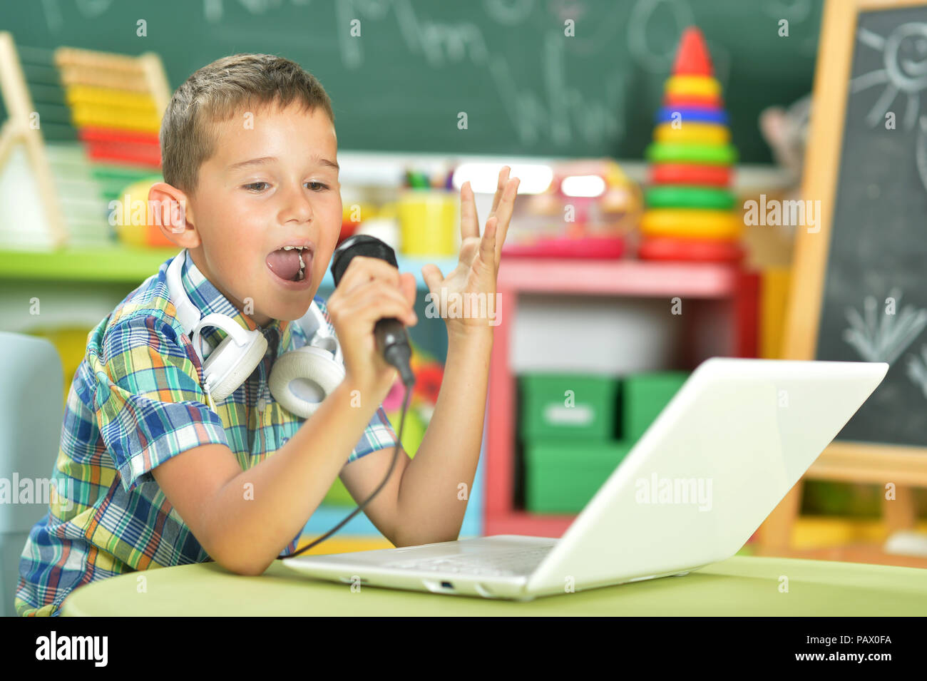 Boy singing karaoke Banque D'Images