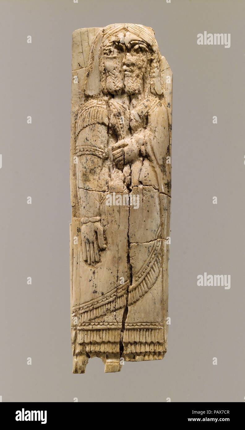 Plaque de meubles avec la figure en relief. Culture : l'assyrien. Dimensions : 6.5 x 1.89 x 0.47 in. (16.51 x 4.8 x 1.19 cm). Date : ca. 9ème-8ème siècle avant J.-C.. Cette plaque d'ivoire a été retrouvé dans un local de stockage à Fort Shalmaneser, un bâtiment royal à Nimrud utilisée pour stocker booty et hommage recueillies par les Assyriens en campagne militaire. Il représente une figure masculine debout, barbus et avec l'épaule-longueur parted cheveux au milieu. Il porte ce qui sont probablement deux longues vêtements, chacun avec un ourlet frangé : un undertunic avec manches courtes qu'il atteint jusqu'à ses chevilles, et une robe sur ce avec decora Banque D'Images