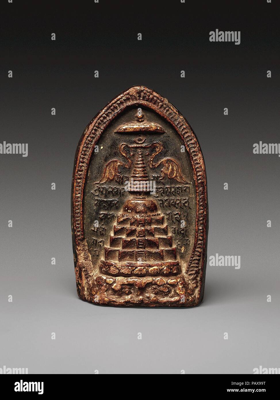 Plaque votive (TSA-Tsa) représentant un stupa. Culture : le Tibet. Dimensions : H. 4 1/8 in. (10,5 cm) ; W. 2 5/8 in. (6,7 cm) ; D. 1 3/8 in. (3,5 cm). Date : 10ème-11ème siècle. Cette tablette d'argile moulée conserve une image d'un stupa de l'Inde du nord (monticule relique)--un type n'existe plus. Le stupa est couronné avec parasols et honorifique ornés de voler des bannières. Écrit en script Sharani dans l'arrière-plan est la croyance bouddhiste ye dharma, exposant les Quatre Nobles Vérités du Bouddha. Musée : Metropolitan Museum of Art, New York, USA. Banque D'Images