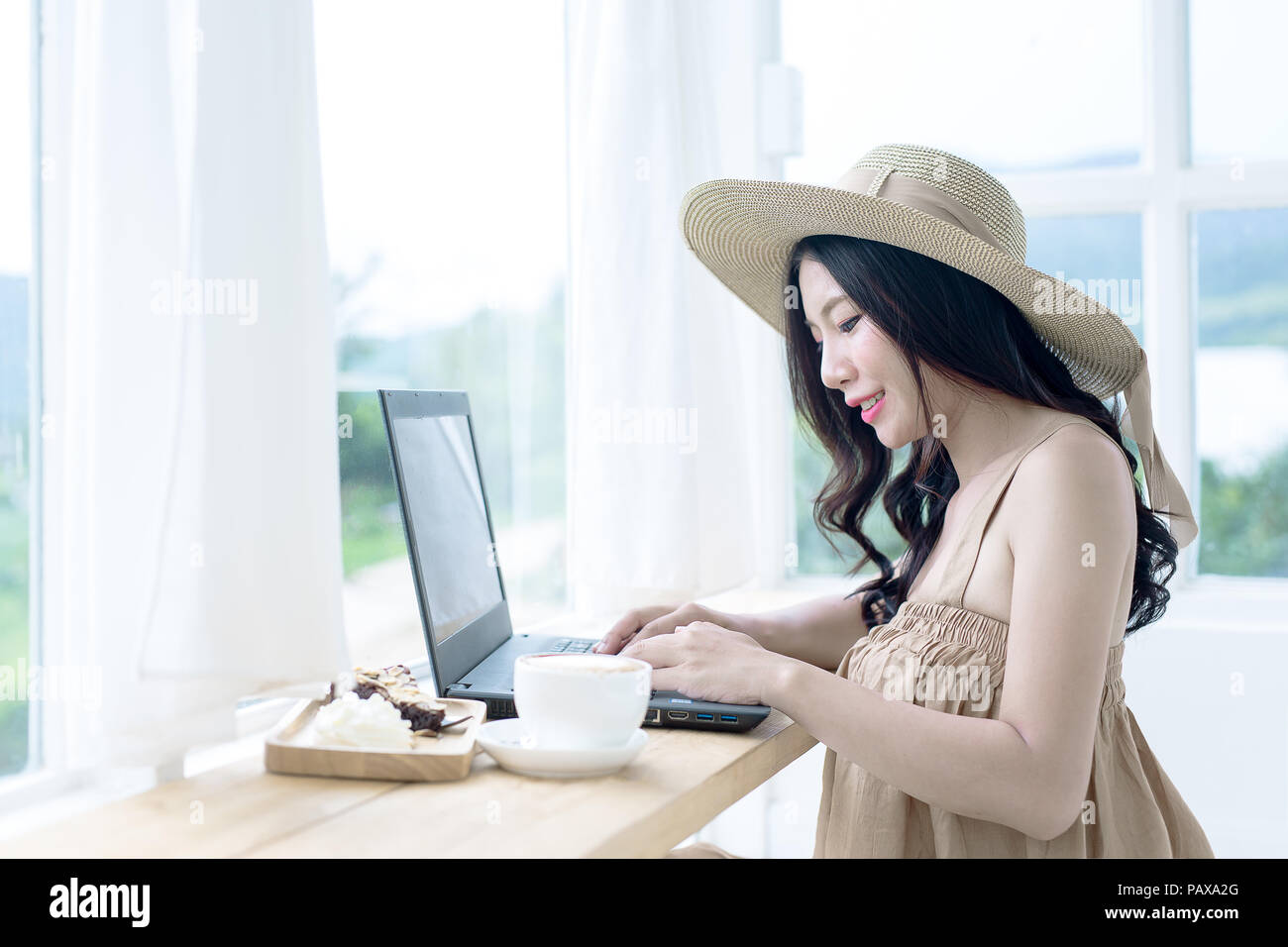 Femme Asiatique au café pour travailler sur un ordinateur portable dans un café. Banque D'Images